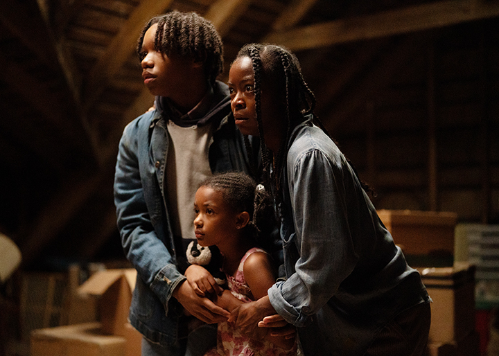 Another still image of Ramona with her son and daughter all in the attic looking at the woman